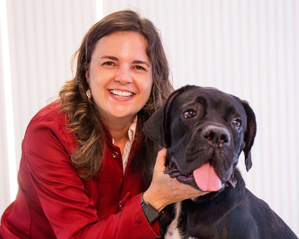 Dra. Mariana Ramos sorrindo ao lado de um cão 